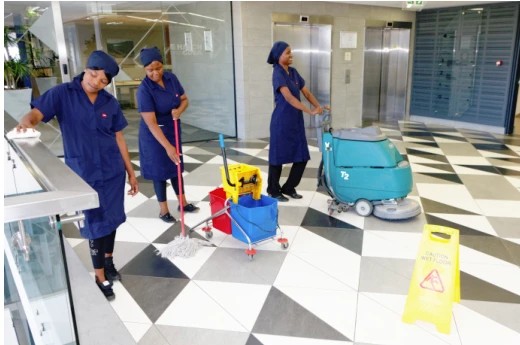 Blue Star cleaning team with a floor scrubber and cleaning equipment