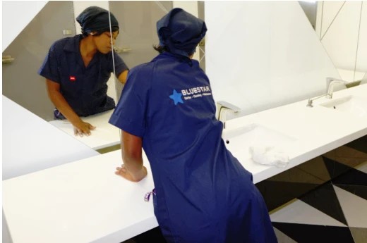 Blue Star cleaner wiping a washroom counter